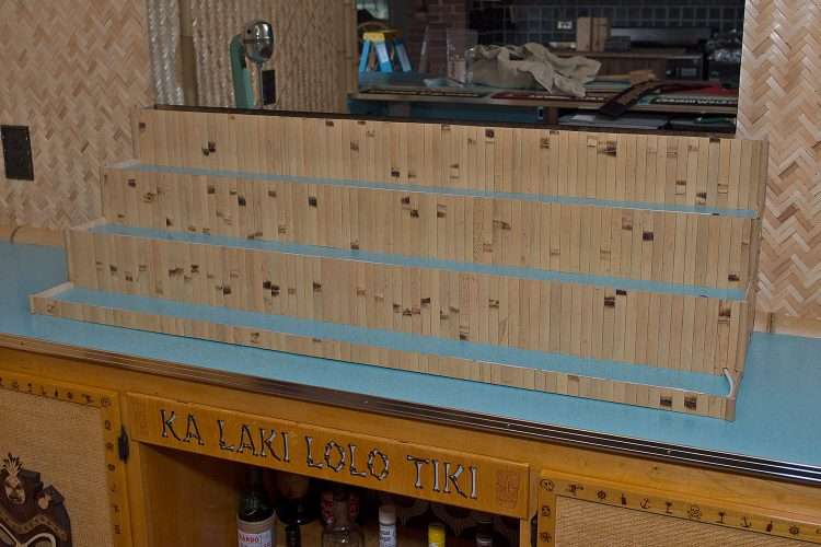 Tiki bar in a private home made by the homeowner. The countertops and bottle risers are made with Light Aqua SparkleLam™.