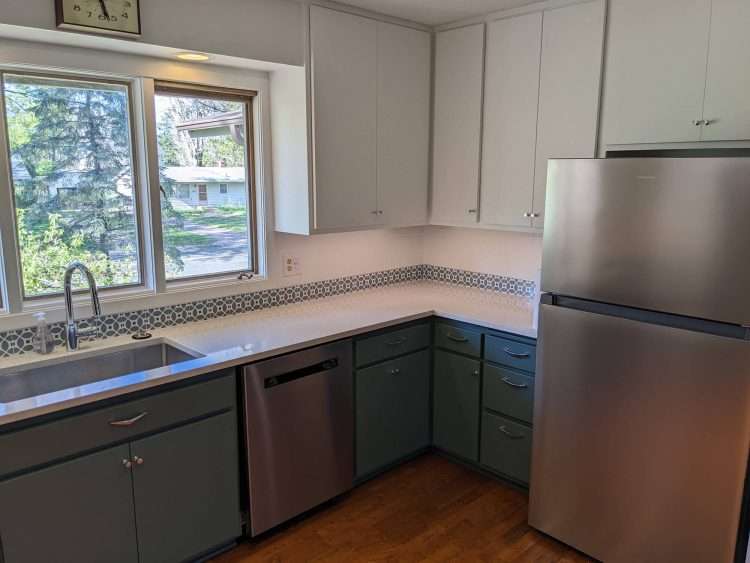 Kitchen remodel with custom Flower decorative tile trim at the countertop.